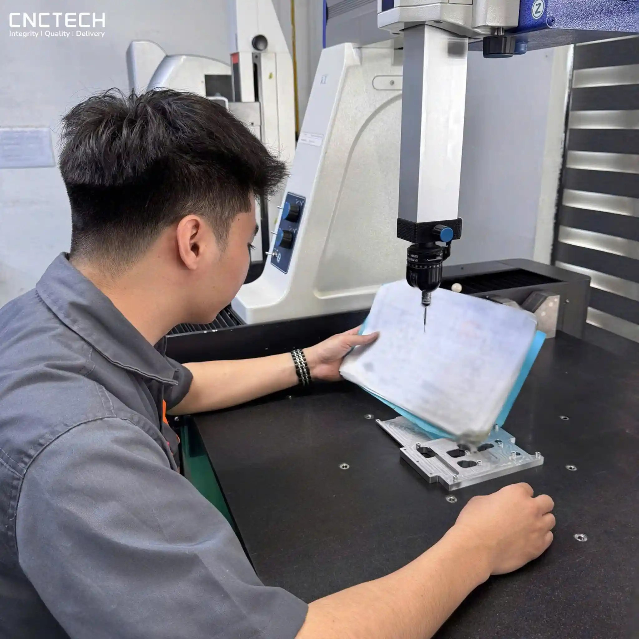 Engineer reviewing CNC engineering drawing and GD&T requirements before machining